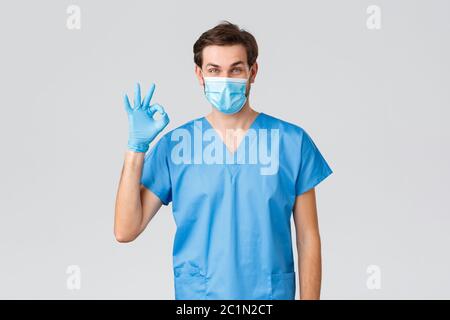 Épidémie de coronavirus, travailleurs de la santé luttant contre la maladie, concept des hôpitaux. Beau médecin, rester optimiste pendant la pandémie de Covid-19, se montrer OK Banque D'Images