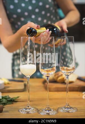 Femme versant du champagne dans un verre avec des bulles Banque D'Images