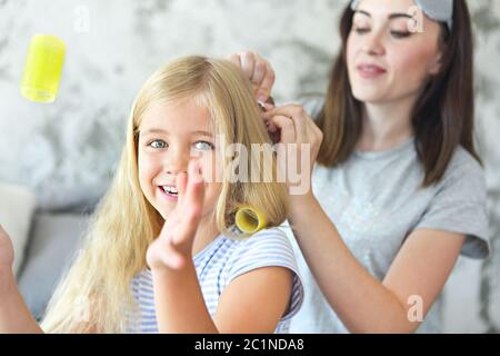 Jolie mère fenroule ses cheveux de filles Banque D'Images