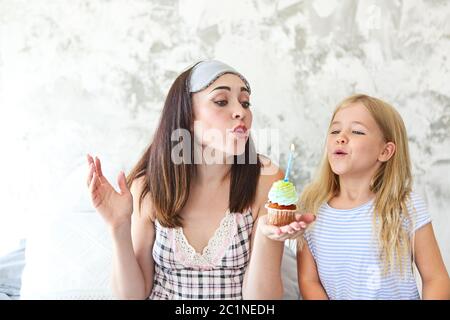 Portrait d'anniversaire de la mère et de sa fille avec cupcake Banque D'Images