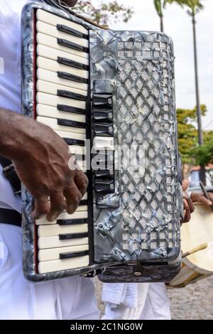 Musicien jouant de l'accordéon à la main à un festival religieux populaire Banque D'Images