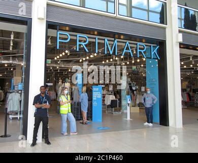 Milton Keynes, Royaume-Uni. 15 juin 2020. La sécurité et le personnel avec masque facial attendent à l'entrée pour diriger les clients vers le magasin Primark.les magasins non essentiels ont été rouverts aujourd'hui dans le 'Intu Shopping Centre' et le 'Center:mk' à Milton Keynes, pour la première fois depuis le blocage de la pandémie du coronavirus (Covid-19). Des mesures de distance sociale étaient en place pour tous les magasins, y compris un système à sens unique pour les acheteurs et de nombreuses files d'attente autour des deux centres commerciaux. Crédit : SOPA Images Limited/Alamy Live News Banque D'Images