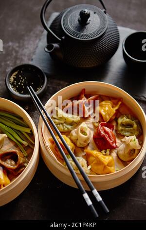 Raviolis chinois traditionnel oriental servi dans la vapeur en bois Banque D'Images