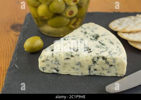 Fromage bleu avec filtre en coin defocused pot d'olives vertes et des craquelins en arrière-plan Banque D'Images