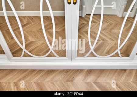 Portes-armoire à miroir coulissant avec décoration superposée. armoire blanche à miroir coulissant sur fond de parquet. Gros plan Banque D'Images