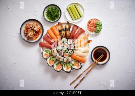 Différents rouleaux de sushi placé sur la plaque ronde en céramique Banque D'Images