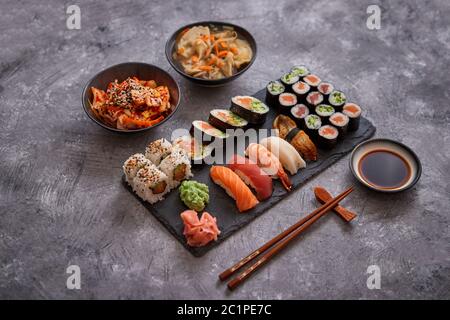 Différents types de sushi sur pierre noire board Banque D'Images