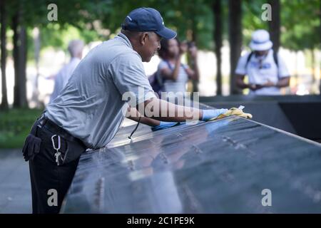 L'homme nettoie la dalle de granit avec les noms des personnes qui sont mortes dans les attaques à New York au Ground Zero Memorial à Manhattan Banque D'Images