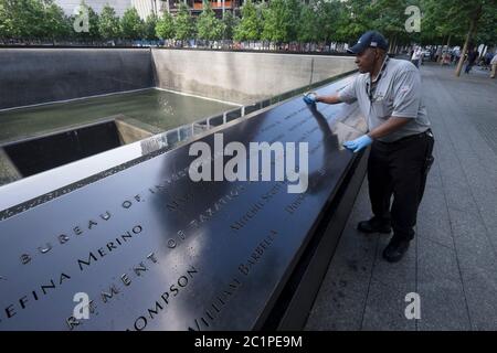 L'homme nettoie la dalle de granit avec les noms des personnes qui sont mortes dans les attaques à New York au Ground Zero Memorial à Manhattan Banque D'Images