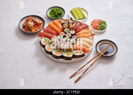 Différents rouleaux de sushi placé sur la plaque ronde en céramique Banque D'Images