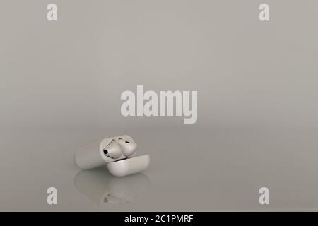 casque sans fil simple blanc dans un coffret de charge sur fond gris avec réflexion dans le verre de la table Banque D'Images