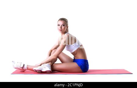 Belle blonde posant sur un tapis de gymnastique Banque D'Images