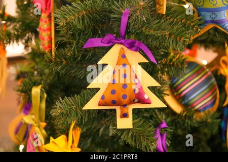 Un cookie et des jouets en bois sous forme d'arbre de Noël et d'oiseau en tissu rose et en coeur sont suspendus sur une branche du tr de Noël Banque D'Images