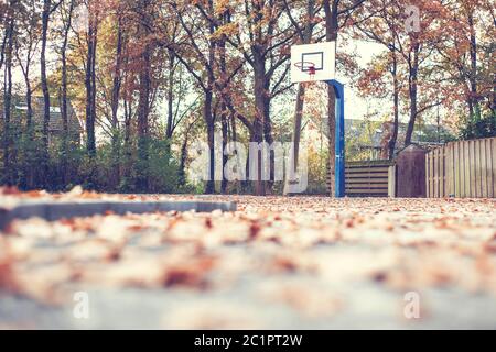 L'automne dans un parc avec un terrain de basket-ball Banque D'Images