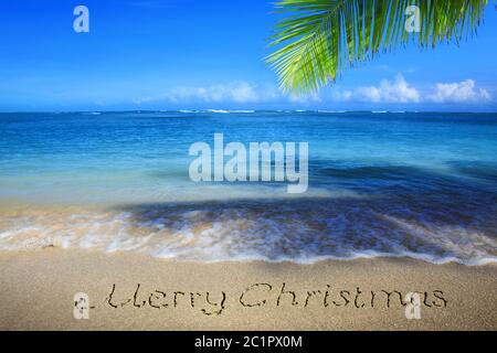 Joyeux Noël Inscription écrite dans le sable blanc des Caraïbes. Banque D'Images