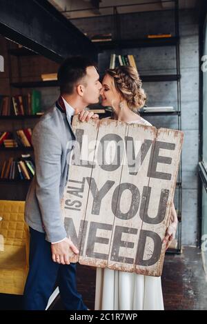 Loving couple holding pancarte tout ce qu'il vous faut, c'est l'amour. Banque D'Images