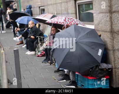 16 juin 2020, Hessen, Francfort-sur-le-main : les journalistes et les visiteurs attendent devant le palais de justice avec parasols et chaises de camping pour l'admission. Le procès de Stephan E., 46 ans, de Kassel, a lieu devant le Sénat de la sécurité de l'État de la Cour régionale supérieure, sous des mesures de haute sécurité. Il aurait tiré sur sa terrasse, il y a un an, le président du district de North Hesse Walter Lübcke, parce que le politicien de la CDU s'était levé pour accueillir des réfugiés. Photo : Boris Roessler/dpa Banque D'Images