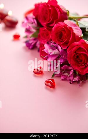 Bouquet de fleurs mixtes avec des roses, des bougies en forme de cœur et des décorations en acrylique Banque D'Images