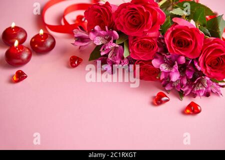 Bouquet de fleurs mixtes avec des roses, des bougies en forme de cœur et des décorations en acrylique Banque D'Images