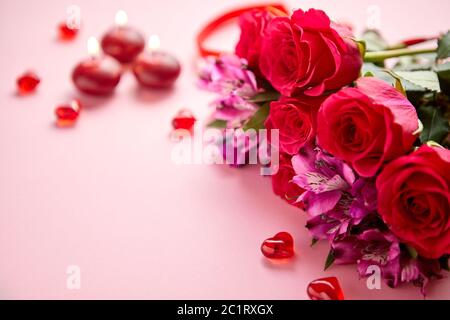 Bouquet de fleurs mixtes avec des roses, des bougies en forme de cœur et des décorations en acrylique Banque D'Images