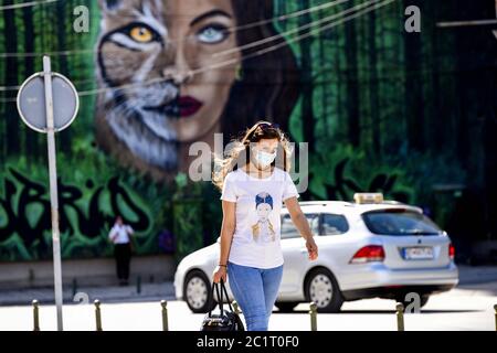 Bitola, Macédoine du Nord. 15 juin 2020. Une femme portant un masque facial marche à côté d'une murale dans la rue de la ville de Bitola, à 180 km au sud de la capitale Skopje, Macédoine du Nord, le 15 juin 2020. Lundi, le ministère de la Santé a signalé 103 nouveaux cas de coronavirus, ce qui porte le total à 4,157, avec 1,723 cas de récupération et 193 décès. Crédit: Tomislav Georgiev/Xinhua/Alay Live News Banque D'Images
