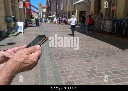 Mains sont en train de tenir un smartphone avec une application de recherche de contact contre le coronavirus et Covid 19 pandémie, une application de corona allemande avertir pour se connecter oth Banque D'Images