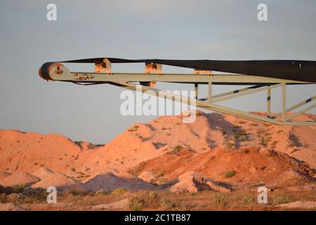 Tapis convoyeur minier dans un état rouillé désexploité au coucher du soleil près de la ville minière de Coober Pedy, dans l'Outback Banque D'Images