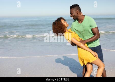 Couple de course mixte dansant sur la plage Banque D'Images