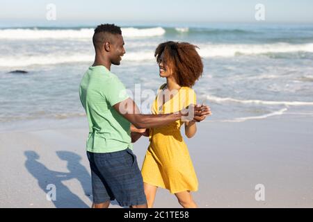 Couple de course mixte dansant sur la plage Banque D'Images