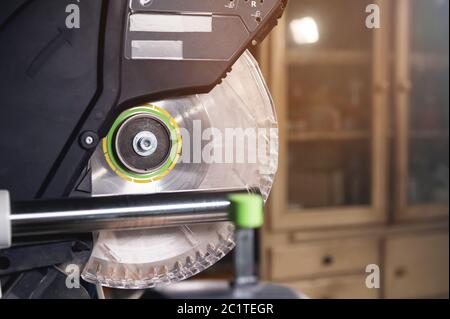 Scie circulaire à lame de scie manuelle en gros plan avec protection en plastique sur les glissières pour couper le bois dans l'atelier à domicile Banque D'Images