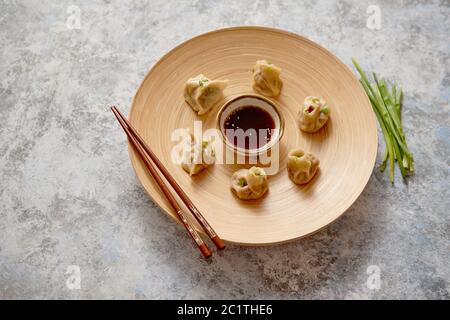 De délicieux raviolis chinois servi sur plaque de bois Banque D'Images