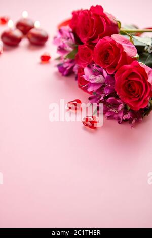 Bouquet de fleurs mixtes avec des roses, des bougies en forme de cœur et des décorations en acrylique Banque D'Images