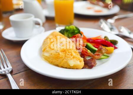 Omelette au poivre, concombre, bakon et salade sur la table Banque D'Images