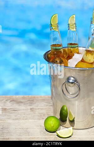 Vue en gros plan du seau avec glaçons, bouteilles de bière et tranches de citron vert Banque D'Images