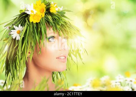 Mère nature beauté concept avec les cheveux de fille fait de fleurs et d'herbe. Banque D'Images