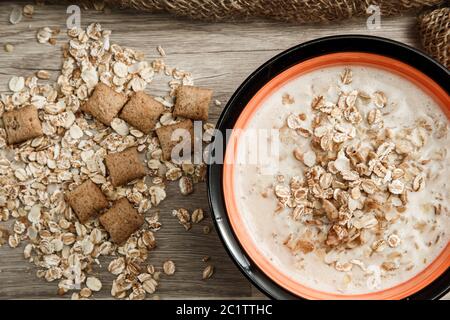 grains de cinq céréales avec garniture au chocolat, remplis de lait sur toile sur fond en bois Banque D'Images