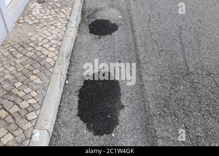 Trous patchés dans la rue locale d'Albufeira, Portugal. Concept d'entretien des routes. Banque D'Images