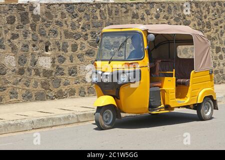 Taxi traditionnel tuk-tuk stationné sur le bord de la route, port d'Andoany ou Hell-ville, Nosy Be, Madagascar. Banque D'Images