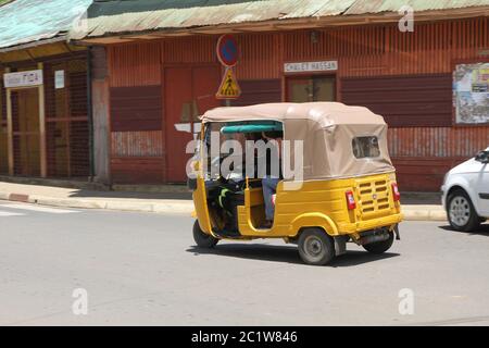 Taxi tuk-tuk en voiture dans la rue, Andoany/Hell-ville, Madagascar. Banque D'Images