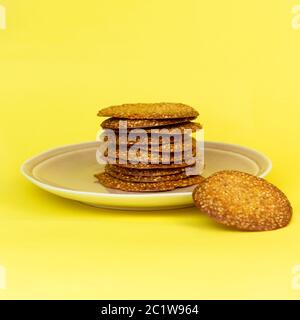 Petits gâteaux au sésame fraîchement préparés faits maison sur fond jaune. Pâtisseries sans gluten. Banque D'Images