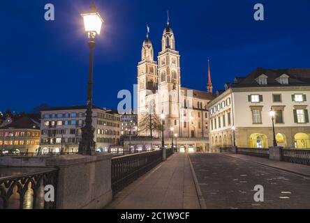 ZURICH, SUISSE - 17 AVRIL 2018 : l'église Grossmünster de Zurich de l'autre côté du Münsterbrücke la nuit. Banque D'Images