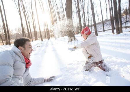 Un père et un fils heureux jouent dans la neige Banque D'Images