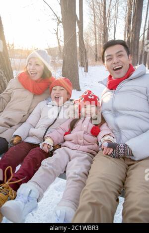 La neige sur les balançoires de famille heureuse Banque D'Images