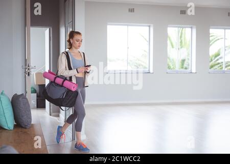 Danseuse de ballet caucasienne regardant son téléphone avec écouteurs Banque D'Images