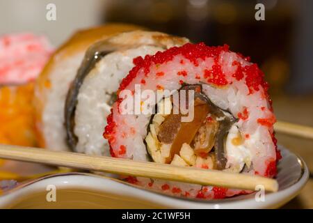 Rouleaux de sushi avec du saumon, l'anguille, le fromage à la crème Philadelphia, caviar tobica et bâtonnets sur la plaque Banque D'Images