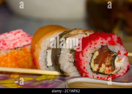 Rouleaux de sushi avec du saumon, l'anguille, le fromage à la crème Philadelphia, caviar tobica et bâtonnets sur la plaque Banque D'Images