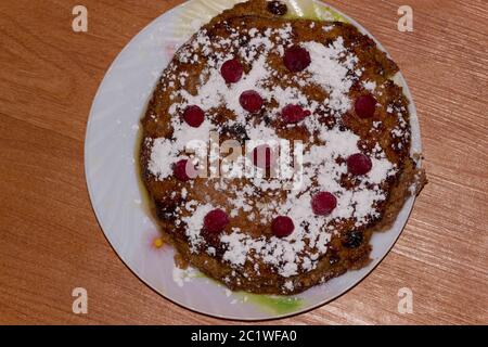 Cassolette de fromage cottage avec les framboises et raisins secs sur une assiette. Fond de bois Banque D'Images