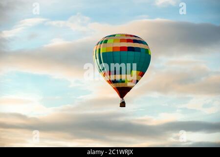 Ballon d'air chaud coloré, grand vol contre le ciel nuageux