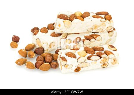 Blocs de Turron disposés avec des amandes et des noisettes , isolés sur fond blanc.