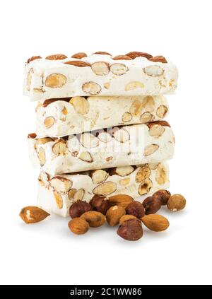 Blocs de Turron empilés, disposés avec des amandes et des noisettes , isolés sur fond blanc